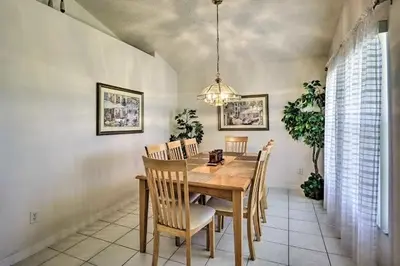 a dining room with a wooden table and chairs at 4 Bedroom Villa - Indian Creek in Kissimmee