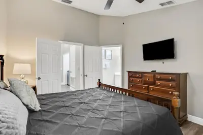 a bedroom with a bed and a flat screen tv at Casa 3Q Windsor Hills c/ Piscina Perto da Disney in Orlando