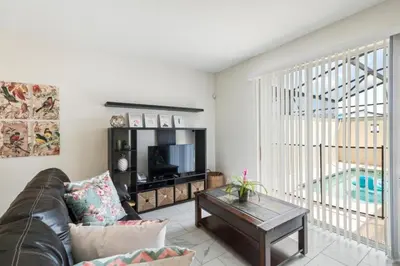 a living room with a couch and a tv at Bright and Modern 4BR Home,Pool,Slides,By Disney in Kissimmee