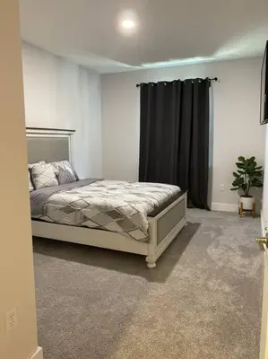 a bedroom with a bed and a black curtain at beautiful home in Kissimmee