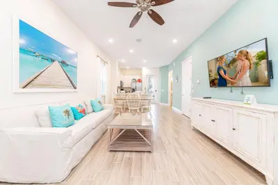 a living room with a white couch and a ceiling fan at Paradise Cottage Near Disney With Margaritaville Resort & Island H2O Access - 8052Dr in Orlando