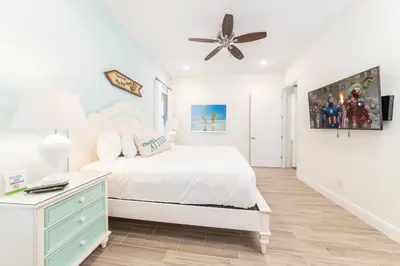 a white bedroom with a bed and a ceiling fan at Paradise Cottage Near Disney With Margaritaville Resort & Island H2O Access - 8052Dr in Orlando