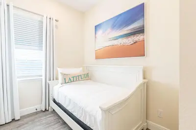 a white bedroom with a bed and a window at Pleasant Cottage Near Disney With Margaritaville Resort & Island H20 Waterpark Access - 2972Sr in Orlando