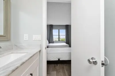 a white bathroom with a bed and a window at Apartment in Florida near Universal and Intern. Dr in Orlando
