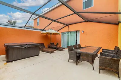 a patio with a table and chairs and an umbrella at Casa 3Q Resort + Jacuzzi Perto Disney in Kissimmee