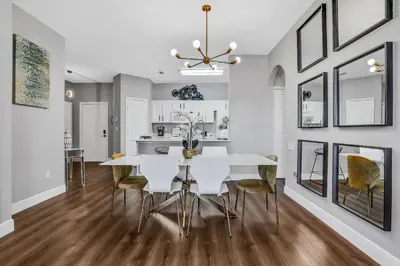a kitchen and dining room with a white table and chairs at 3Q/2B 10min da DISNEY Acesso Resort in Orlando