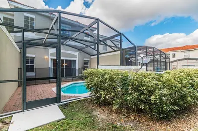 a glass house with a pool in front of a building at Casa 3Q Bella Vida c Piscina Próx Disney e Walmart in Kissimmee