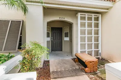 a house with a bench in front of a door at Casa 3Q Bella Vida c Piscina Próx Disney e Walmart in Kissimmee