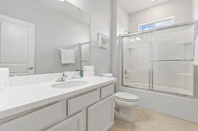 a white bathroom with a sink and a toilet at New Home 8 Bedrooms At Bella Vida in Kissimmee