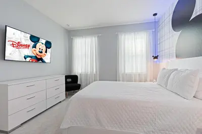 a bedroom with a white bed and a tv on the wall at New Home 8 Bedrooms At Bella Vida in Kissimmee