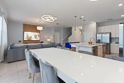 a kitchen and living room with a white table and chairs at New Home 8 Bedrooms At Bella Vida in Kissimmee