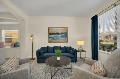 a living room with a blue couch and a table at Family Villa with Private Pool Game Room & Themed Rooms in Kissimmee