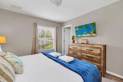 a bedroom with a bed and a dresser and a window at Family Oasis Cozy Retreat with Bunk Room in Kissimmee