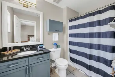 a bathroom with a sink and a toilet and a mirror at Family Oasis Cozy Retreat with Bunk Room in Kissimmee