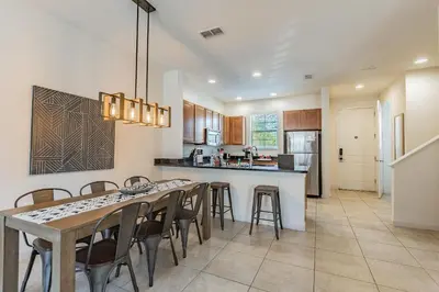 a kitchen and dining room with a table and chairs at 2 Suítes, Jacuzzi priv. perto da DISNEY in Kissimmee