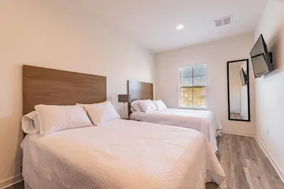 a bedroom with two beds and a window at 2 Suítes, Jacuzzi priv. perto da DISNEY in Kissimmee