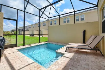 a swimming pool with a chair in front of a building at Casa 4Q c/ Piscina Priv. e Vista Lago in Kissimmee