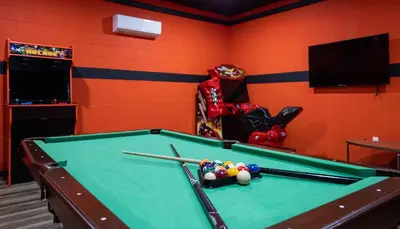 a billiard room with a pool table with balls and bats at Casa c/ Piscina, Sala de Jogos e 6 Suítes in Orlando