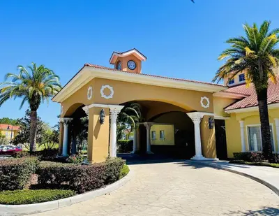 a yellow house with palm trees and a driveway at Ideal 3 BR Resort Villa with Laundry in Kissimmee