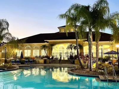 a large swimming pool in front of a building with palm trees at Ideal 3 BR Resort Villa with Laundry in Kissimmee
