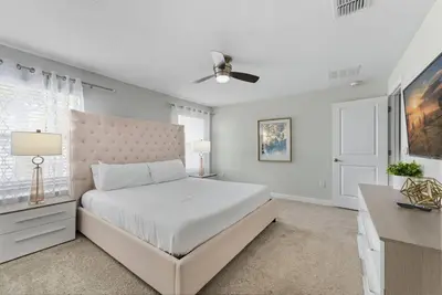 a white bedroom with a bed and a ceiling fan at Casa de Luxo em Storey Lake Resort in Kissimmee