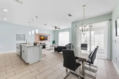 a dining room and living room with a table and chairs at Casa de Luxo em Storey Lake Resort in Kissimmee