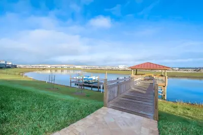 a wooden boardwalk leading to a dock on a lake at Casa de Luxo em Storey Lake Resort in Kissimmee