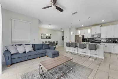 a living room with a blue couch and a kitchen at Casa de Luxo em Storey Lake Resort in Kissimmee