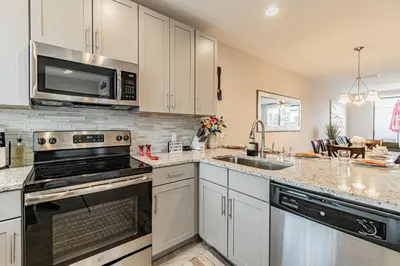 a kitchen with white cabinets and a stove top oven at 3Q/2.5B *Ótima Localização* in Kissimmee