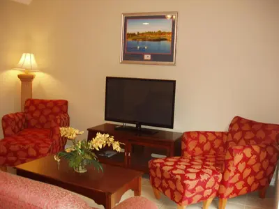 a living room with two chairs and a flat screen tv at Four Bedroom Villa in Coral Cay in Kissimmee