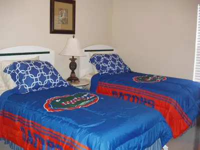 a bedroom with two beds and a table with a lamp at Four Bedroom Villa in Coral Cay in Kissimmee