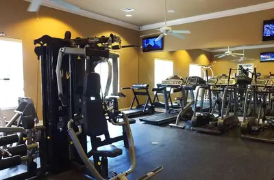 a gym with several rows of tread machines in a room at 4BR Lakefront - Themed Rooms - Pool & BBQ! in Kissimmee