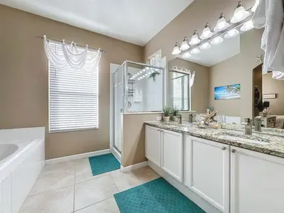 a bathroom with two sinks and a tub and a shower at 4 Bed in Windsor Palms Resort - Steps to Disney villa in Kissimmee
