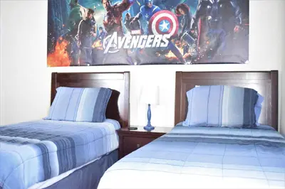 a bedroom with two beds and a poster of avengers at 2551 Oneida Grantham! in Kissimmee