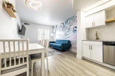 a kitchen and dining room with a table and a blue chair at One bedroom unit near Epic Universe and Universal, free parking in Orlando