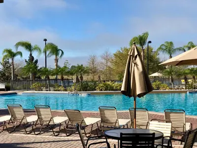 a pool with chairs and a table and an umbrella at P42 New Townhouse at Vista Cay Walking distance to CCCO in Orlando