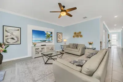 a living room with a couch and a ceiling fan at Spotless 6 bedroom Villa - Storey Lake - Hot tub - Free Water Park - 15 Mins to Disney in Kissimmee