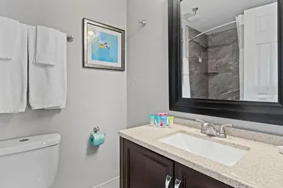 a bathroom with a sink and a toilet and a mirror at 6165 Carrier Drive 1001 in Orlando