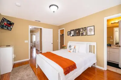 a bedroom with a large white bed and a kitchen at Epic Arty Retreat near Disney in Kissimmee