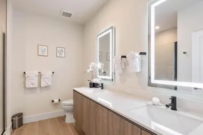 a bathroom with a sink and a toilet and a mirror at Modern Townhouse Heated Pool Disney Orlando 17244 in Orlando