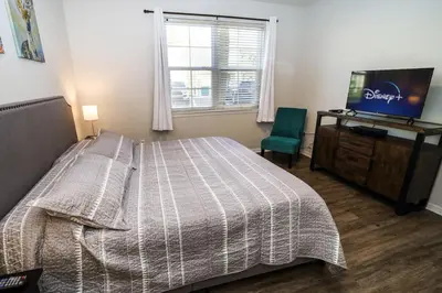 a bedroom with a bed and a television and a chair at Runaway Beach Club Resort Condo Apt Disney 15103 in Kissimmee