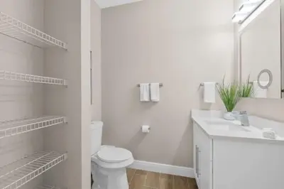 a white bathroom with a toilet and a sink at 8496 Resort 3BR Condo by Disney World Orlando in Kissimmee
