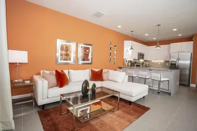 a living room with a white couch and a kitchen at Modern Townhouse Heated Pool Disney Orlando 1500R in Orlando