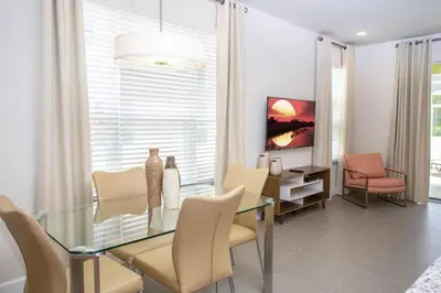 a dining room with a glass table and chairs at Modern Townhouse Heated Pool Disney Orlando 1500R in Orlando