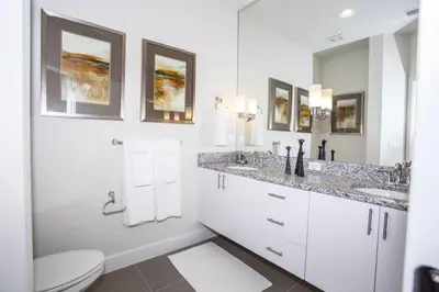 a white bathroom with two sinks and a toilet at Modern Townhouse Heated Pool Disney Orlando 1500R in Orlando