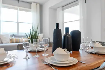 a wooden table with plates and wine glasses on it at Modern Storey Lake Resort Disney Orlando 3191-307 in Kissimmee