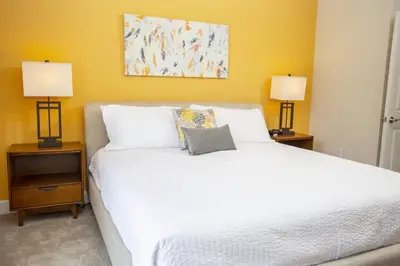 a bedroom with a large white bed with two lamps at Modern Townhouse Heated Pool Disney Orlando 1502R in Orlando