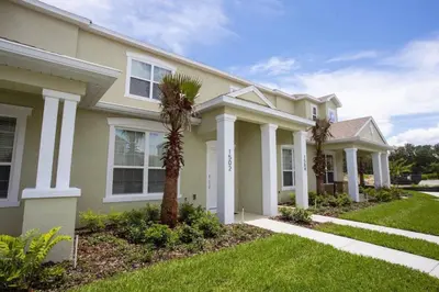 a house with a palm tree in the front yard at Modern Townhouse Heated Pool Disney Orlando 1502R in Orlando