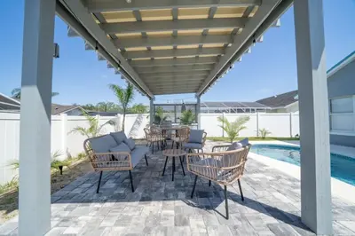 a patio with chairs and a table next to a pool at Vacation Oasis Home with Private Pool and Grill 8615 in Kissimmee