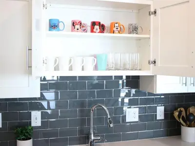 a kitchen with blue subway tile and white cabinets at Modern Storey Lake Resort Disney Orlando 3150-303 in Kissimmee